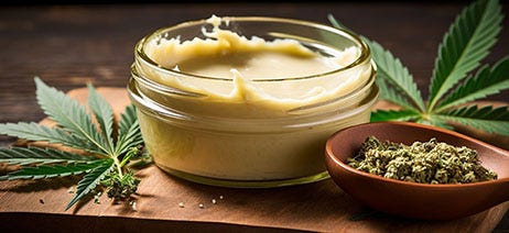 Cookie with the word 'love' on it with a cannabis bud on top