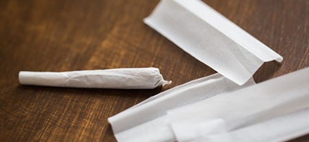 Cannabis pre-rolls next to loose rolling paper