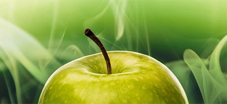 Green apple in front of green smoke against a green background