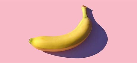 Ripe, yellow banana on a pink background