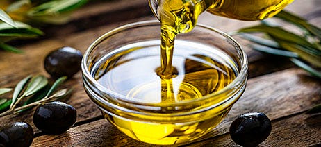 Cooking oil pouring into a clear glass bowl