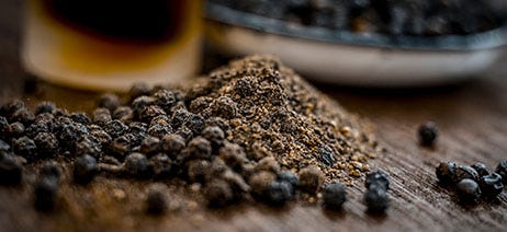 Peppercorns spilling out on a wooden table