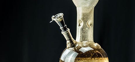 Dirty glass bong on a black background