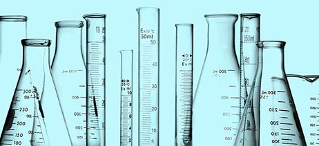 Glass beakers in a variety of sizes on a turquoise background