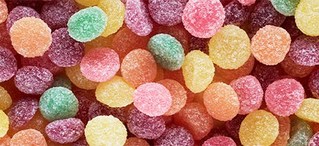 Cannabis gummies in a variety of colors piled on top of each other