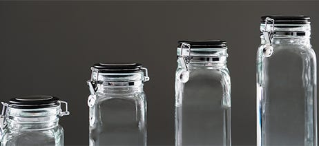 Four glass mason jars in different sizes with clear liquid inside