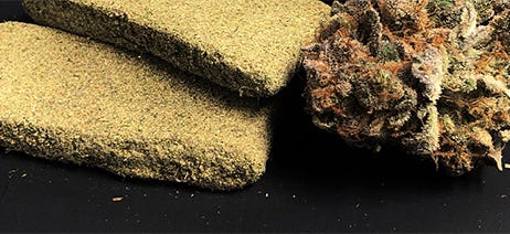 Two bricks of cannabis hash next to two nuggets of cannabis flower