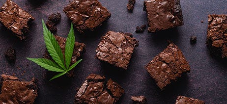 chocolate brownies spread across a table with a cannabis leaf on top