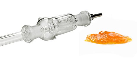 Cannabis nectar collector next to wax concentrate