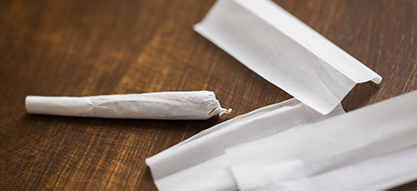 Cannabis pre-rolls next to loose rolling paper