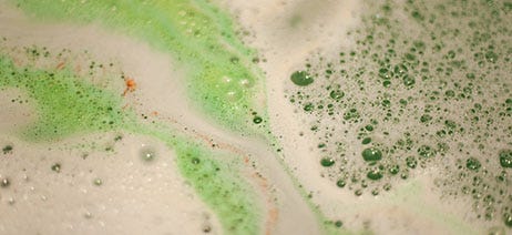Soapy water with bubbles and green swirls