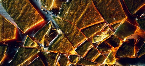 Sheet of shatter concentrate broken up on a black table