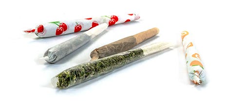 Five cannabis pre-rolls in different colored rolling paper