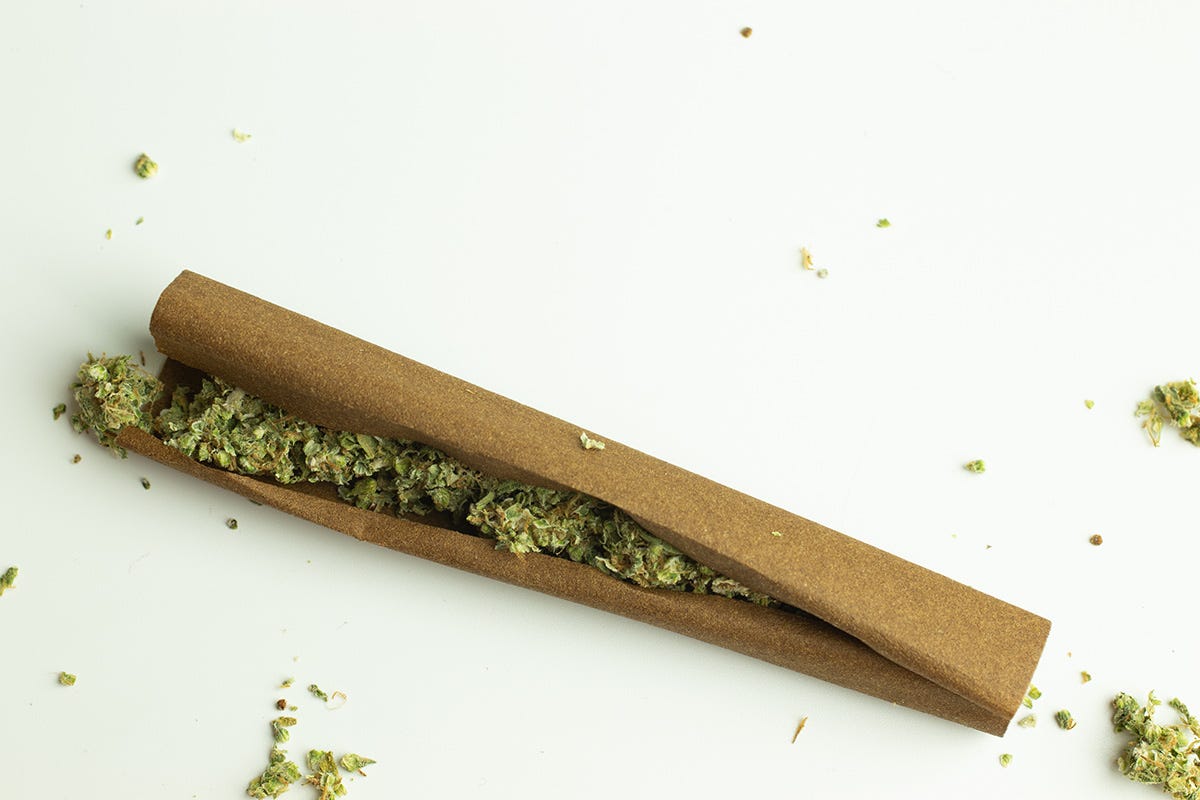 Cannabis flower next to a joint that needs to be rolled and a complete joint