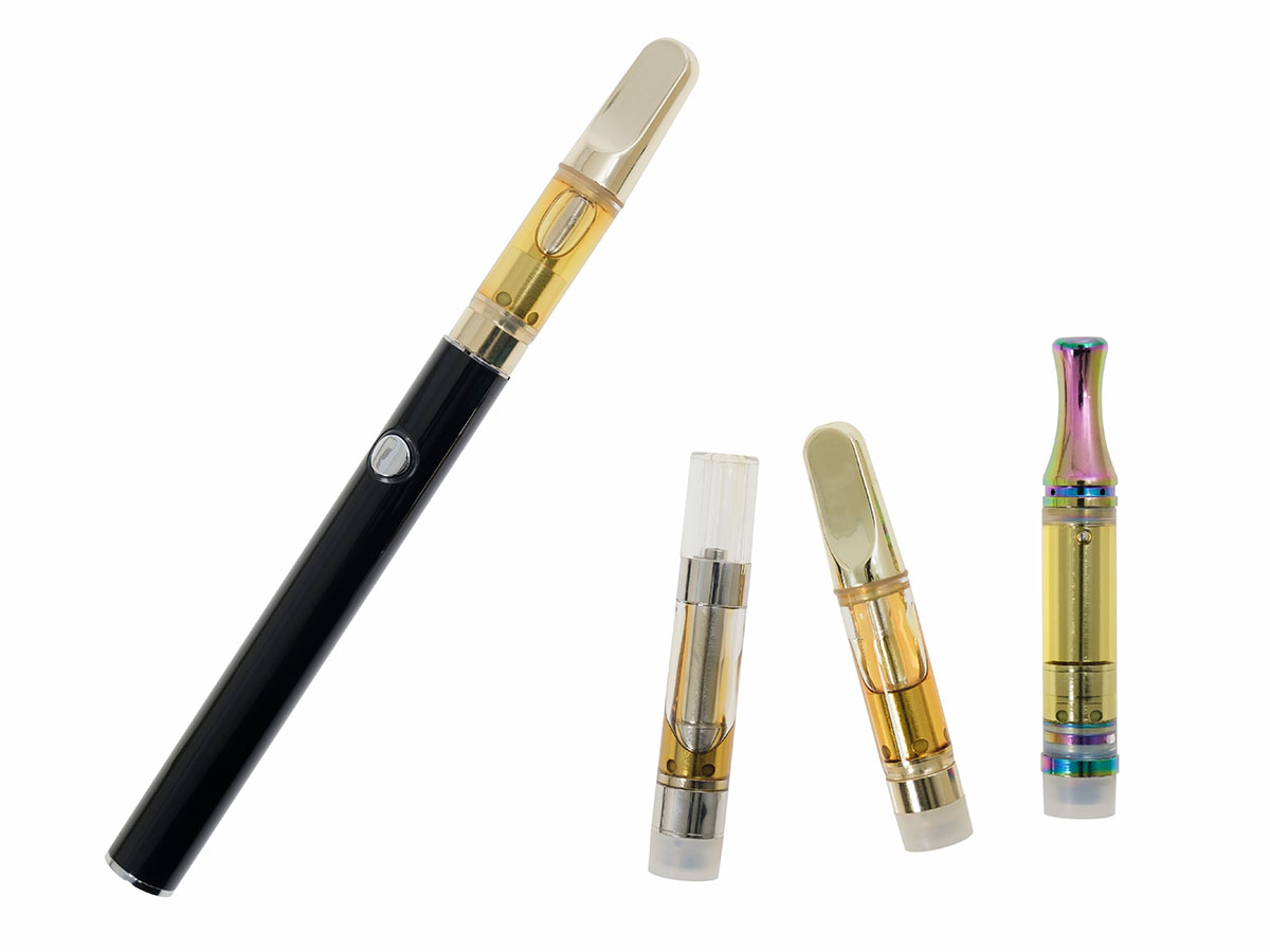 Cannabis vape next to three cartridges