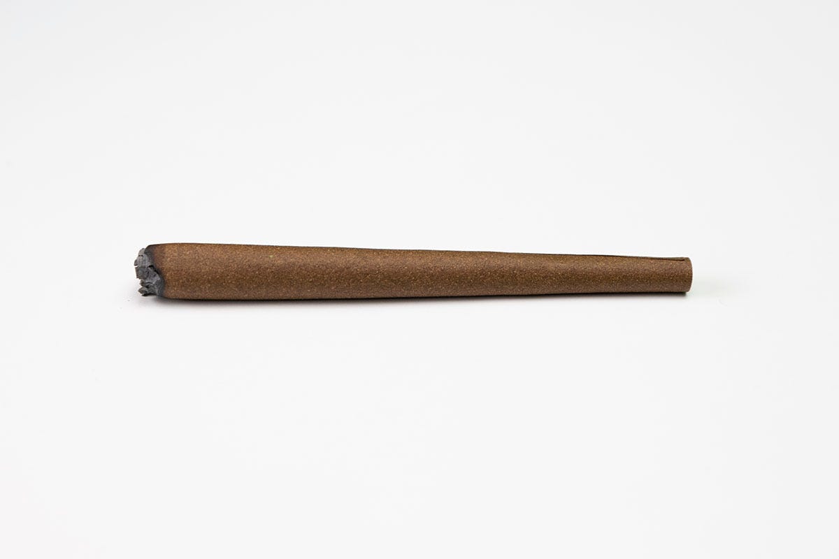 Marijuana blunt sitting horizontally on a white background