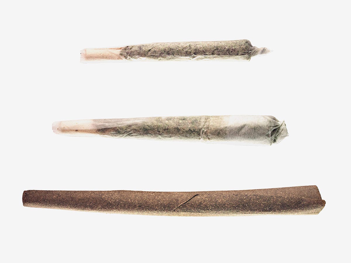 Two joints and a blunt sitting horizontal on a white background