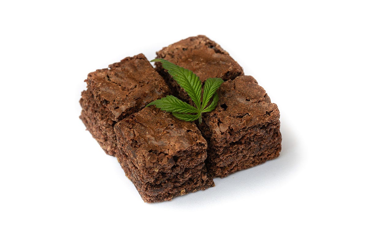Four square brownies with a cannabis leaf on top