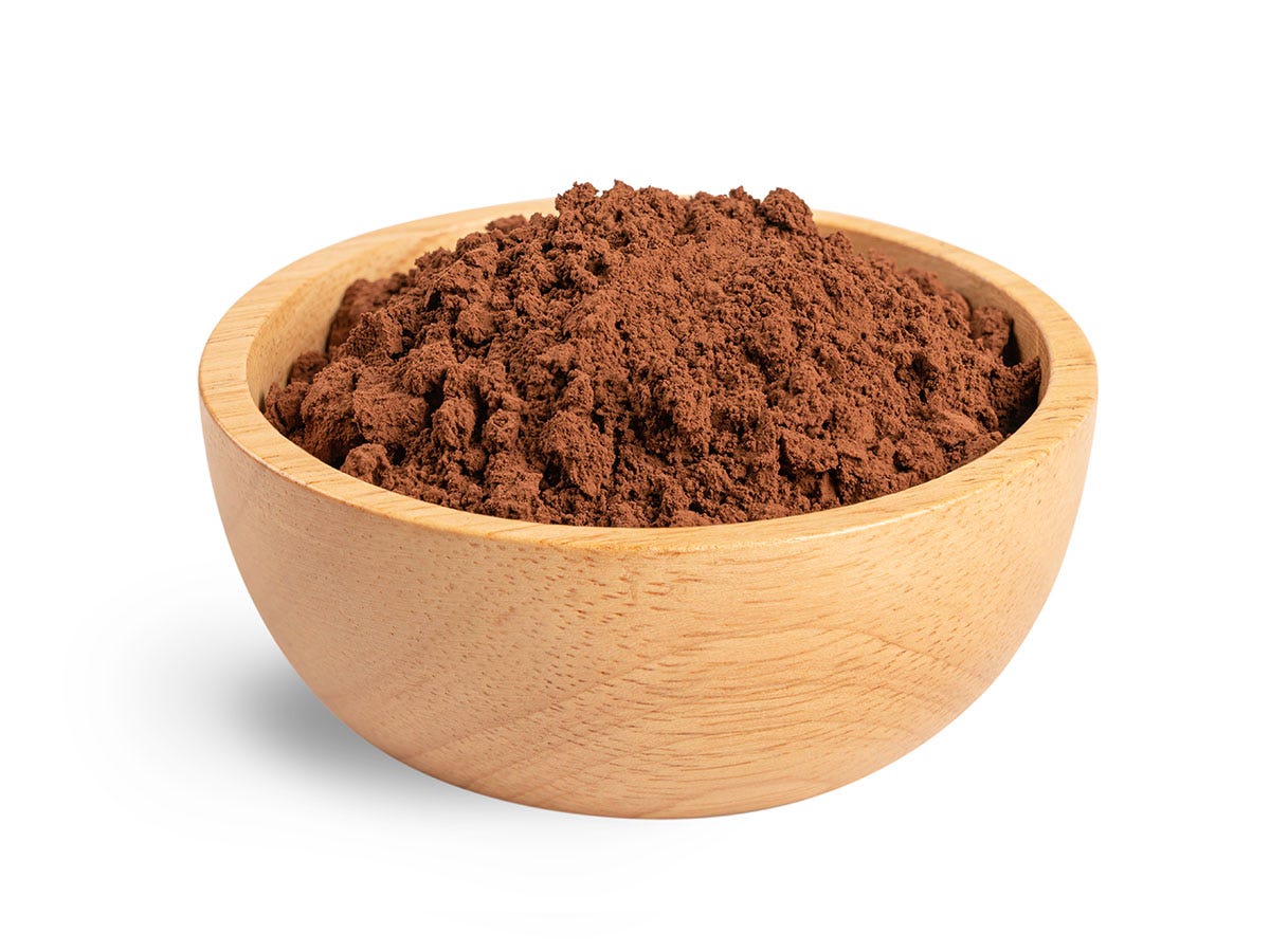 Cocoa powder in a light brown bowl on a white background