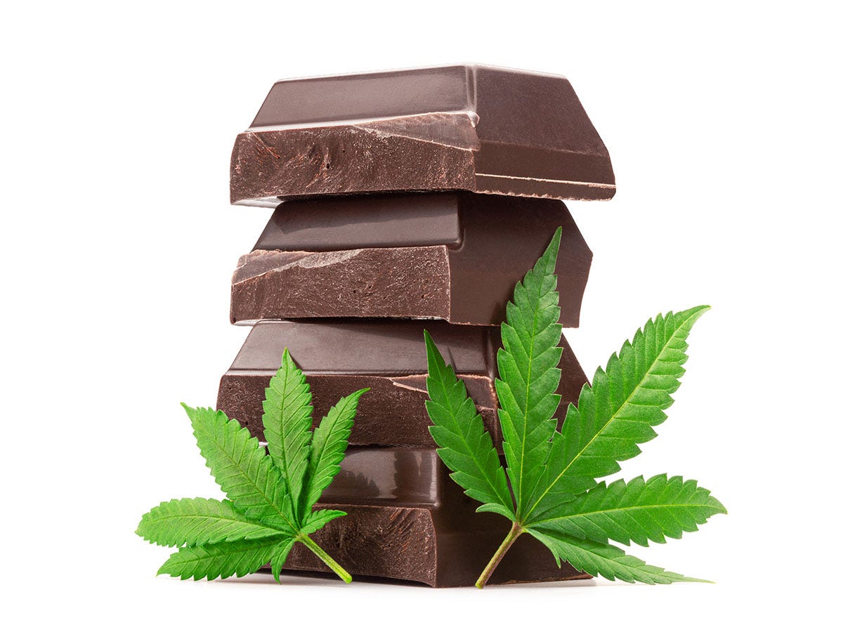 Stack of chocolate bar pieces with cannabis leaves in front on a white background