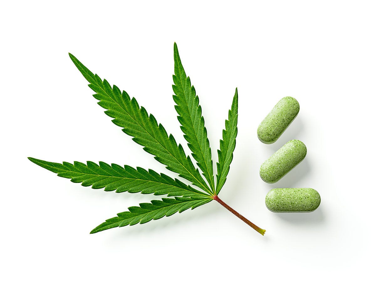 Cannabis leaf next two three green pills