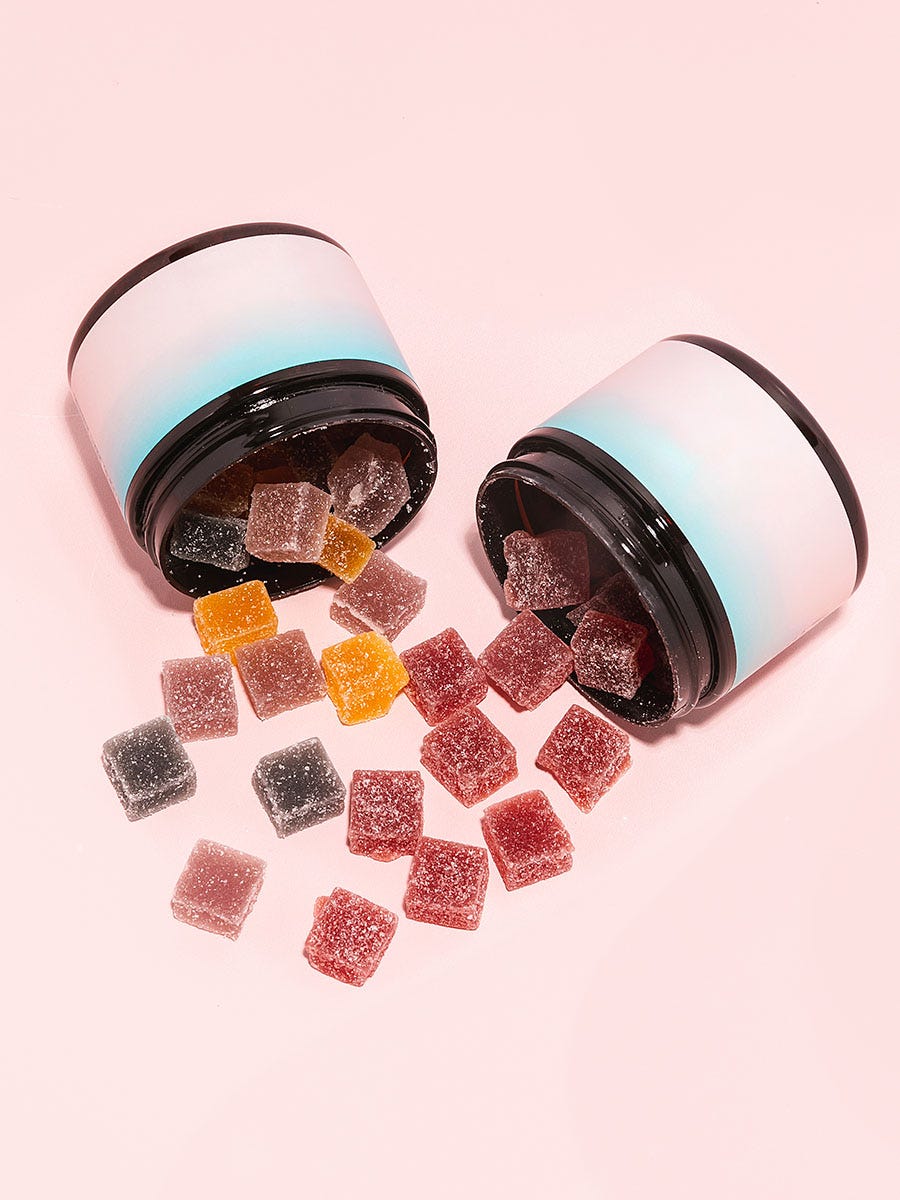 Two jars with multicolored gummies pouring out