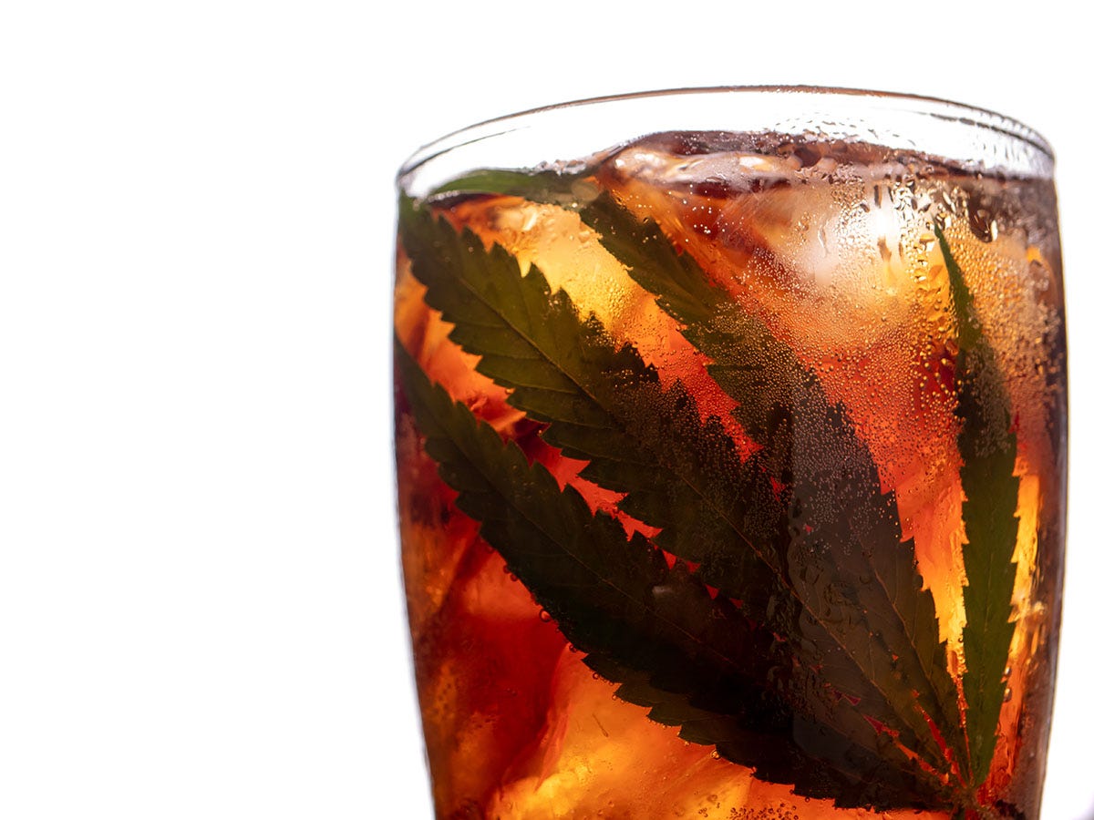 A glass of soda containing a marijuana leaf