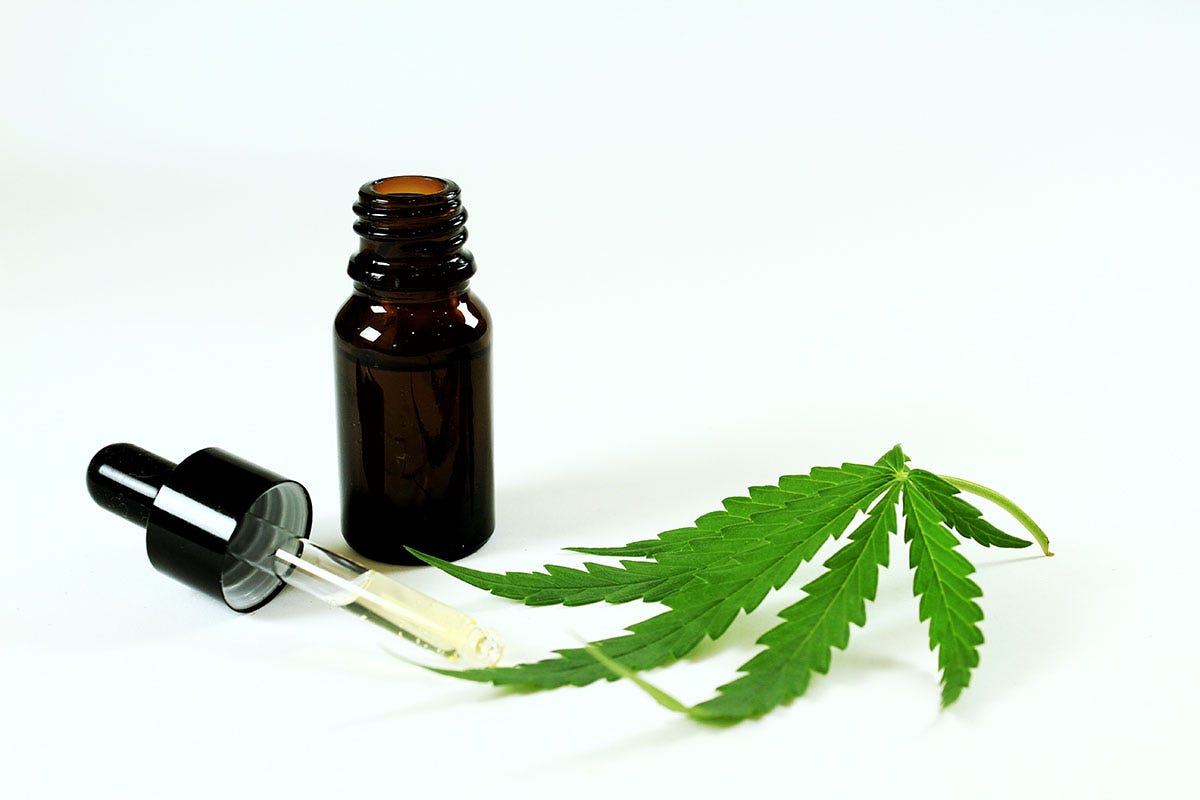 Tincture bottle next to a dropper and a cannabis leaf
