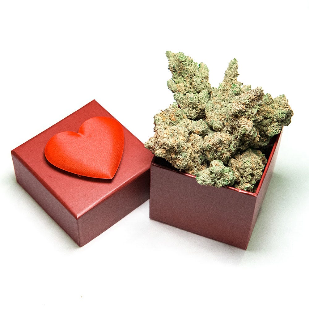 Cannabis flower exploding out of a red box with a heart on the lid