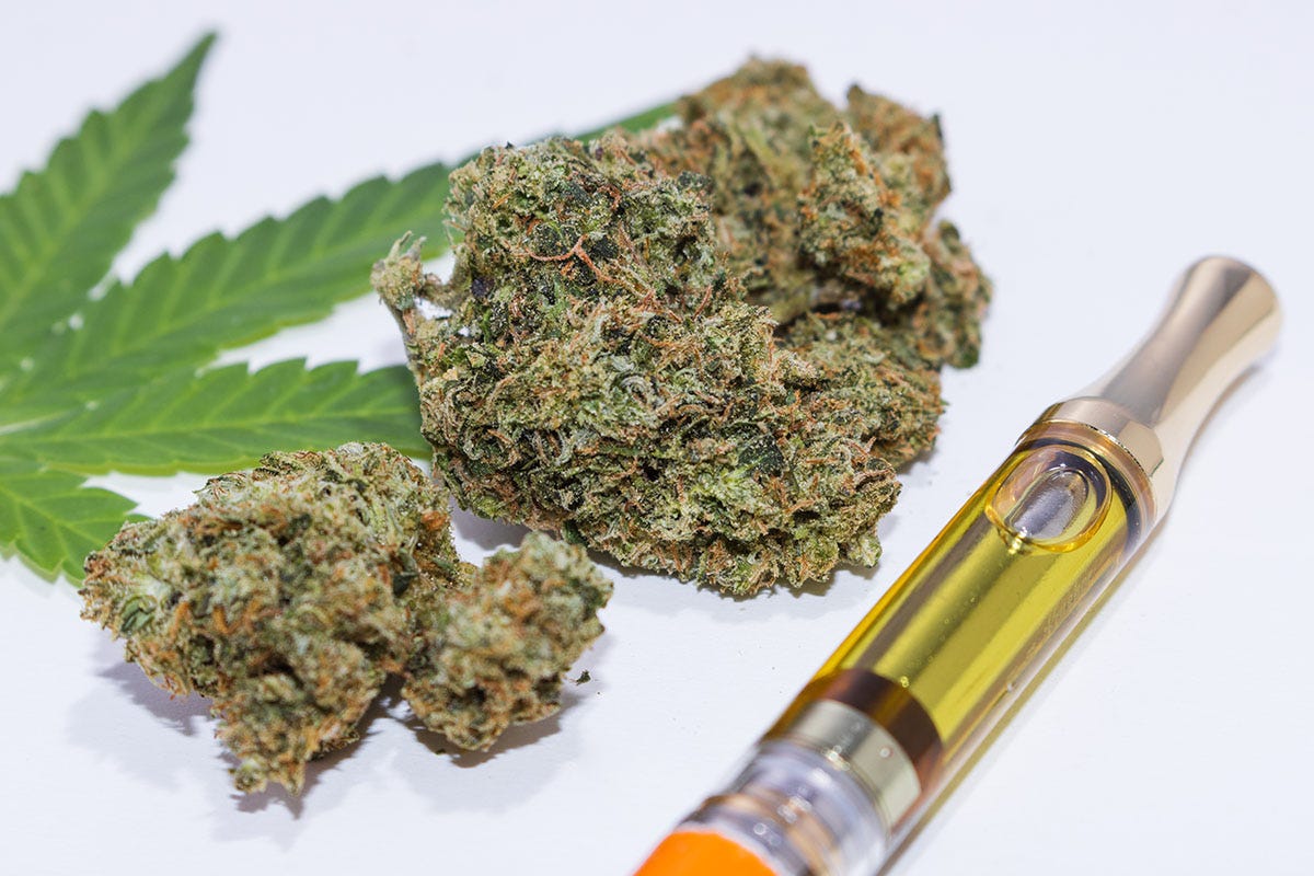 Marijuana vape pen next to nuggets of flower